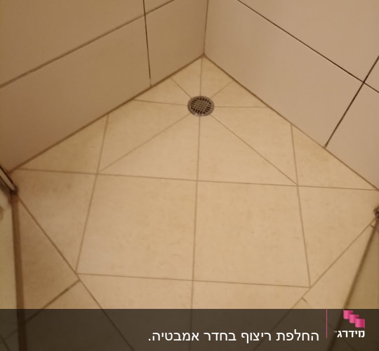 רצפת מקלחת מרוצפת עם ניקוז במרכז